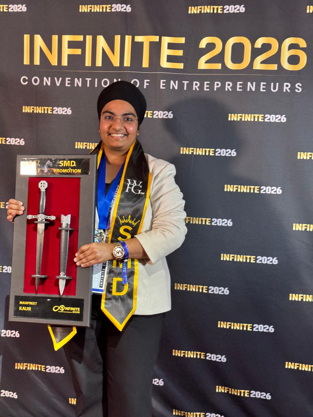 Receiving the SMD Promotion sword at Infinite 2026 Convention of Entrepreneurs — a recognition of leadership and dedication to building a team of financial professionals